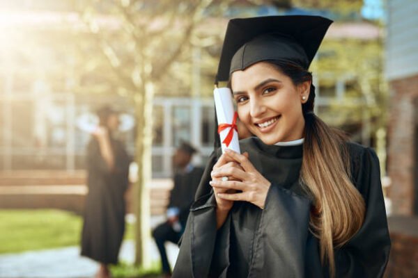 Portrait of a happy young woman holding a diploma on graduation day Portrait of a happy young woman holding a diploma on graduation day